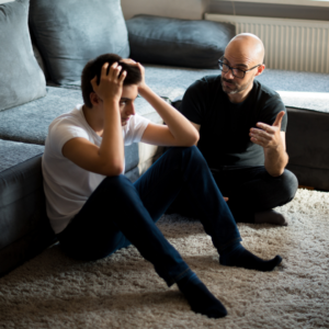 dad and son sitting on the floor talking