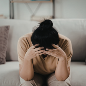 women sitting on the couch with head in her hands
